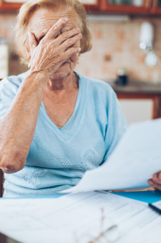 woman covering her face stressed over finances